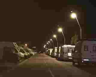Vista nocturna de caravanas aparcadas en la vía pública