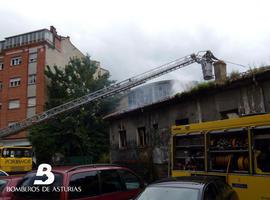 Efectivos de Bomberos luchan para sofocar un incendio en una nave de pegatinas y plásticos en Colloto